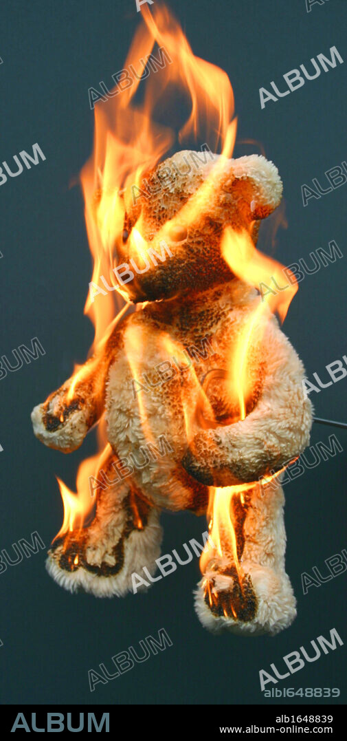 A child's toy bear (teddy bear) set alight and in flames. Toys are made of fire retardant fabrics.