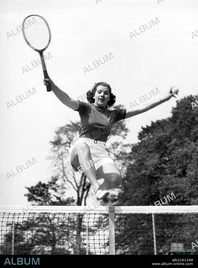 Westport, Connecticut: May 23, 1936 The 18 year old woman leaping over the tennis net was named 'Typical American Girl Athlete' by the Athletic Committee of the Longshore Club in Westport.
