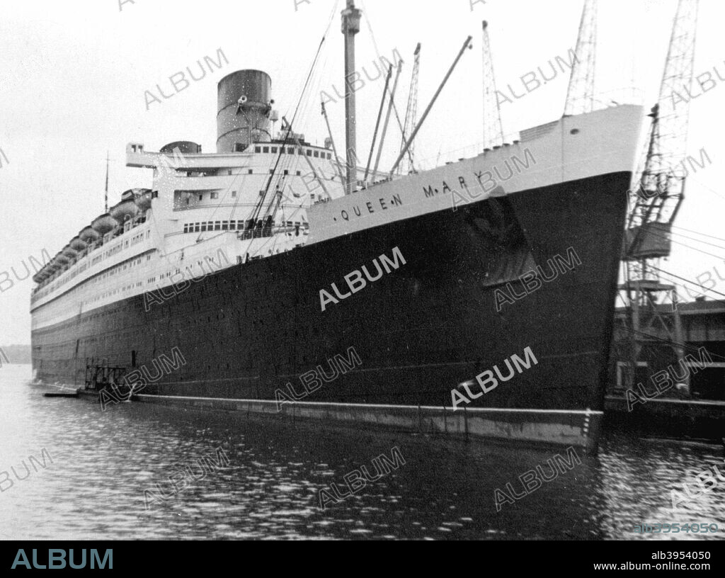 Ocean liner RMS 'Queen Mary', 20th century. Docked in harbour. Built by John Brown & Co on Clydeside for the Cunard White Star Line, the 81,000 ton Queen Mary was the largest ocean liner in the world when she was launched in 1934. Apart from an interlude as a troopship during World War II, she dominated the transatlantic route, together with her sister, the 'Queen Elizabeth', until she was retired from service in 1967. Since then she has been a hotel and tourist attraction moored at Long Beach, California.