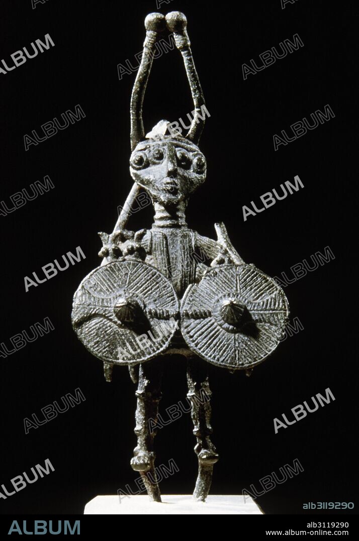 PREHISTORIA. CULTURA NURAGICA. ESTATUILLA DE UN DIOS GUERRERO O DE UN HEROE LEGENDARIO CON CUATRO BRAZOS Y DOS ESCUDOS. Realizada en bronce y datada en los siglos VIII-VII a. C. Procede del Abimi (Teti). Museo Arqueológico de Cagliari. Cerdeña. Italia.