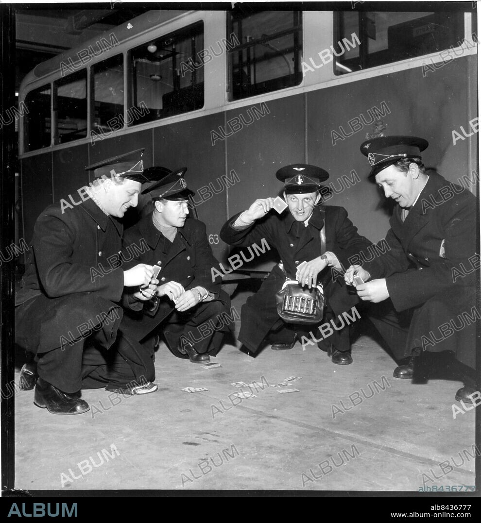 Strejk vid lokaltrafiken stoppar spårvagn och buss i Malmö mars 1951. Konduktörer i uniform spelar kort vid stillastående buss. Arbetsmarknad konflikt strejk spårvagnsstrejk 1951. Malmö lokaltrafik buss bussar. Yrke konduktör busskonduktör spårvagnskonduktör. (c) Bertil Rubin / Sydsvenskan / IBL.