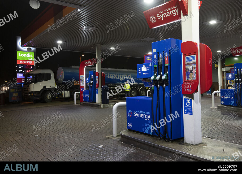 TIM WOODCOCK. Esso petrol station forecourt with tanker delivering fuel, 2020.