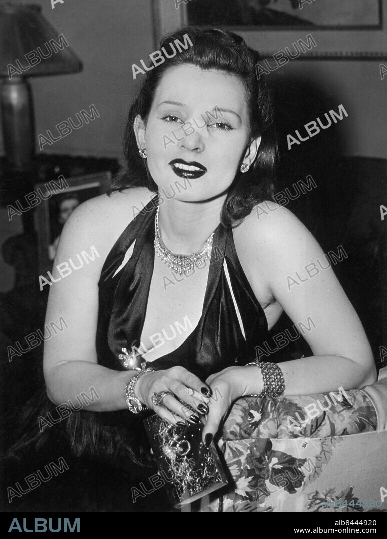 Orig. bildtext... SARI GABOR HER NOSE SLIGHTLY OUT OF JOINT New York. Sari Gabor (Mrs. Conrad Hilton) the Miss Hungary of 1936 was photographed at her new York apartment bearing evidence of an injury to her nose. The red-haired, green-eyed beauty explained to the press that her nose was broken by a jealous wife who wielded an iron poker in a rage a few days ago. 4.26.45 Anm. Z Z Gabor, f 1917, ungerskfödd amerikansk skådespelerska. Skönhetsdrottning Näsor Blessyrer Skadad Plåster Halsband Armband Ringar Örhängen Broscher Handväskor Urringat Dekolletage CD508 persons: ZSA ZSA GABOR sites: USA;NEW YORK.