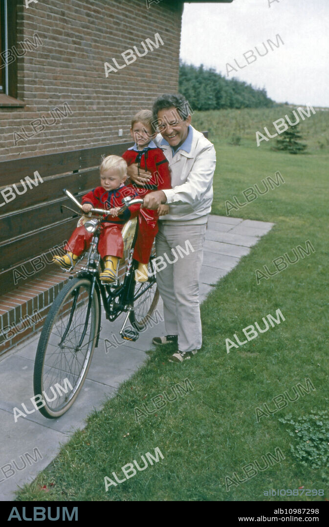 Hans Rosenthal on his bicycle with his grandchildren Beate (front) and Felix at Utersum on Foehr island, Germany 1980.