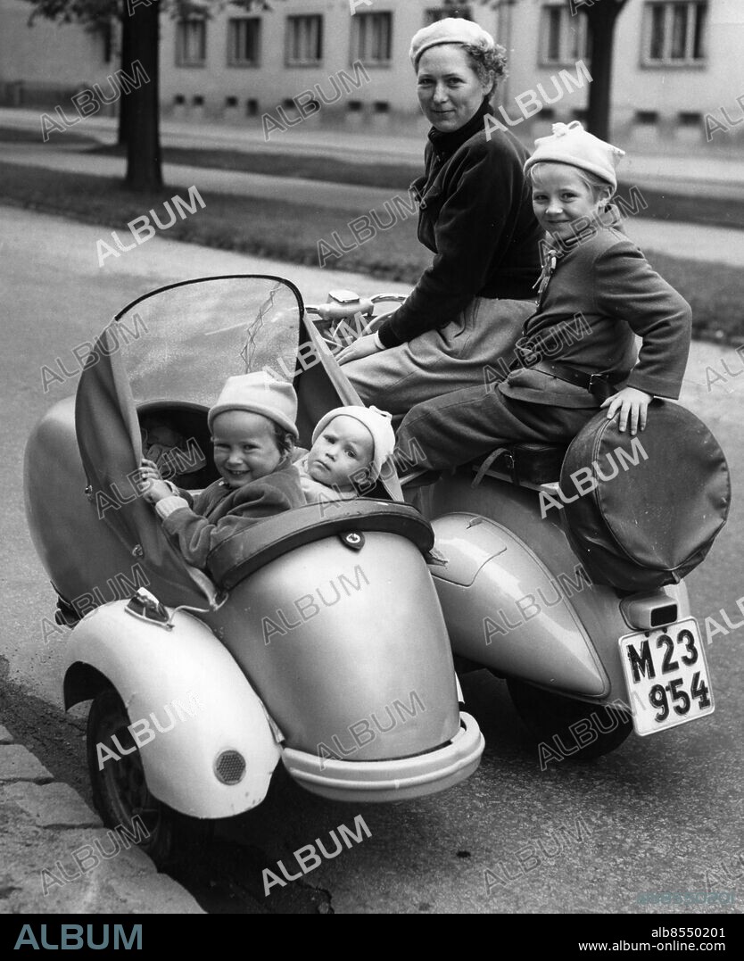Scooterekipage scooter med sidovagn i Malmö 1954.. Fru Margareta Svensson, Uddeholmsgatan i Malmö är ute på körtur med barnen Christina på bönpallen och i sodovagnen Waino och Thomas.. Foto: C.A.Raasum / Sydsvenskan Bild / IBL Bildbyrå *** Local Caption *** Mrs Margareta Svensson goes for a ride in her scooter with her three children, Malmoe, Sweden 1954,.