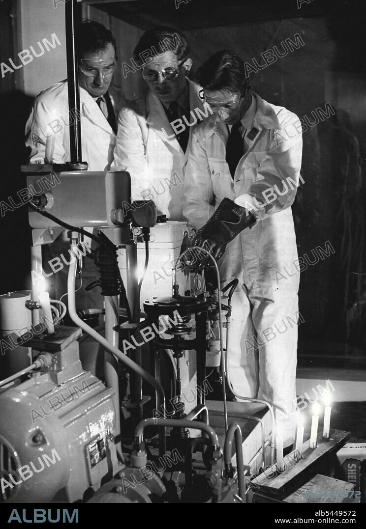 Candlepower Beats Nuclear Fission -- The boundless energy of the atom is useless in face of the electricians' strike, and scientists resort to the old-fashioned candle to install an atomic energy machine at the Engineering and Marine Exhibition at Olympia, London, to-night (Tuesday). The machine, which appears on the Shell-Mex and B.P. Limited stand, will demonstrate the use of radio-active isotopes for the investigation of engine wear. (Latest official estimates said that 5,000 electricians would be on strike by Monday). September 01, 1953. (Photo by Reuterphoto).