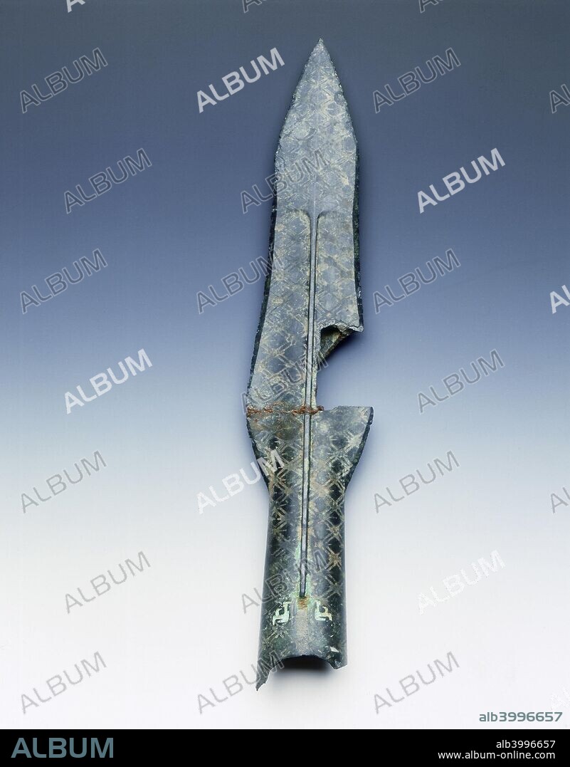 Bronze spearhead with rhombus and recessed lattice diaper pattern, Eastern Zhou dynasty, China, 5th century BC. Bronze spearhead from the State of Yue, with curved cutting edges. Down the centre is a ridge with two shallow depressions on either side. There are a pair of sunken decorative units near the shaft opening. This type of weapon is associated with the eastern States of Wu and Yue and is an example of the kind of prestige pieces that circulated between rulers of different states.