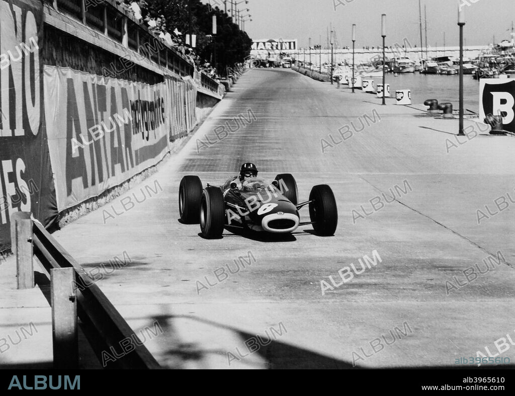 Graham Hill, Monaco Grand Prix, 1964. Hill drives his BRM past the harbour, on his way to victory, one of his 5 Grand Prix wins at the circuit.