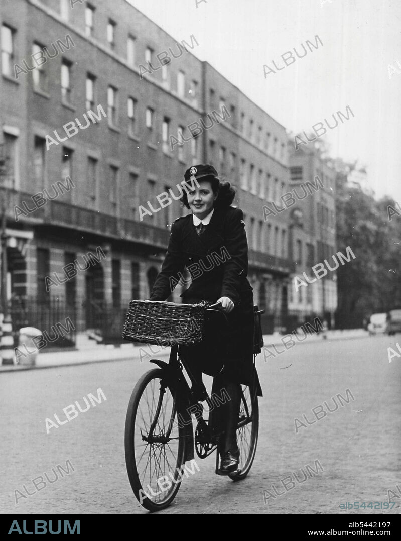 District Nurse Of Bloombsury -- Kathleen cycles off to work again along Bedford Place. Her bags go in a carrier at the back. March 24, 1948. (Photo by Pictorial Press).
