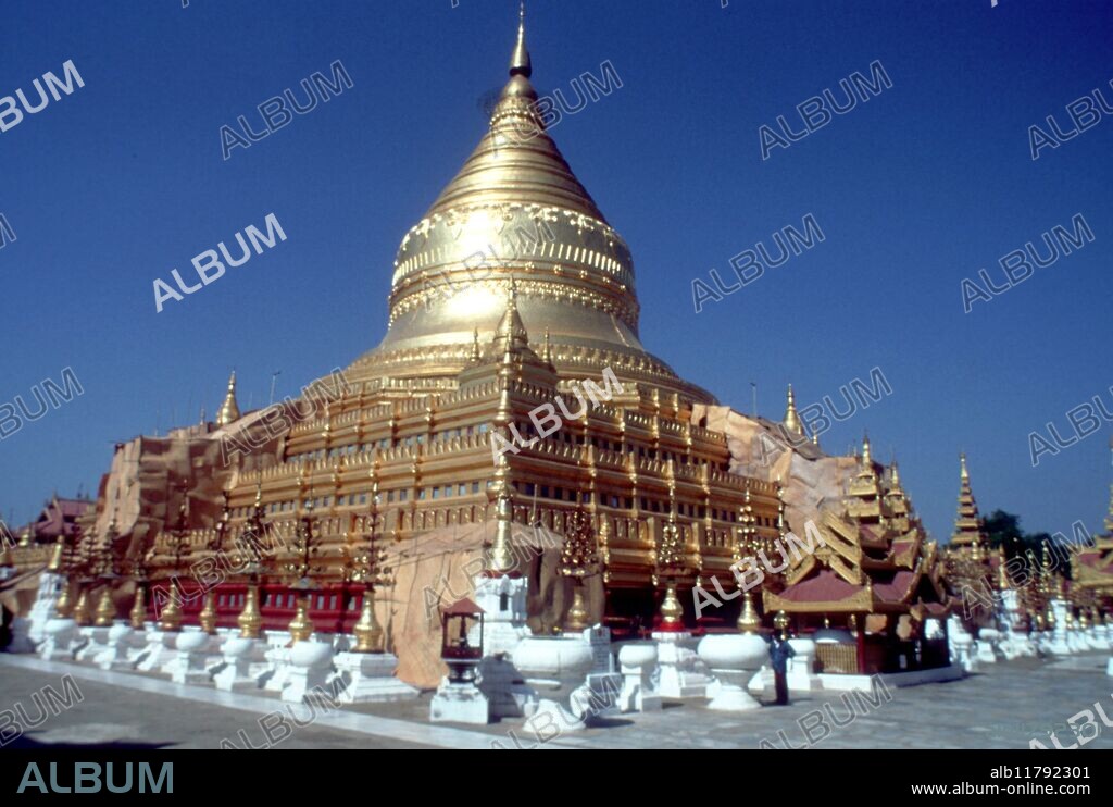 Shwezigon pagoda (late 11th century) at Bagan, Myanmar (Burma) - contains Buddha relics. The Shwezigon Pagoda is a famous pagoda located in Nyaung U, a town near Bagan, in Myanmar. It is a prototype of Burmese stupas, and consists of a circular gold leaf-gilded stupa surrounded by smaller temples and shrines. Construction of the Shwezigon Pagoda began during the reign of King Anawratha and was completed during the reign of King Kyanzittha, in 1102. The pagoda is believed to enshrine a bone and tooth of Gautama Buddha. Within the compound of the Shwezigon Pagoda is a stone pillar containing Mon language inscriptions dedicated by King Kyanzittha. ©TopFoto / Fortean *** Local Caption ***.