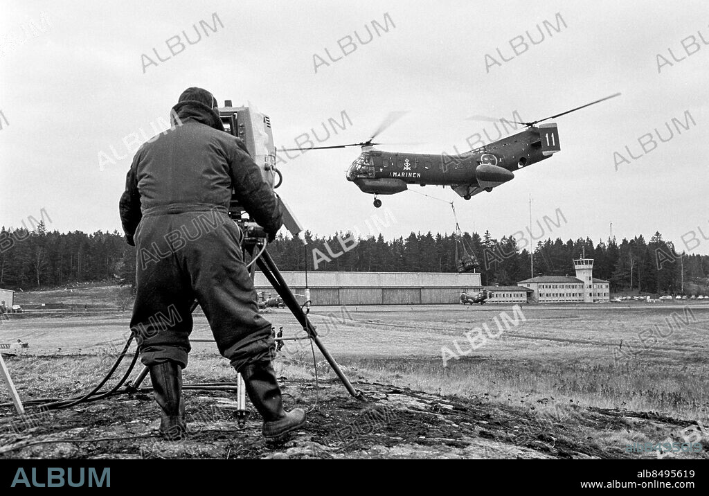 BERGA 1967-02.. Provsändning av färg-TV från Berga helikopterskola. Här ses en kameraman filma en helikopter i luften.. Foto: Bo-Aje Mellin / RiR / SVT / Kod: 5600. Notis publ. i RiR 15/67 sid. 54.. RiR 18519 sv/v neg.