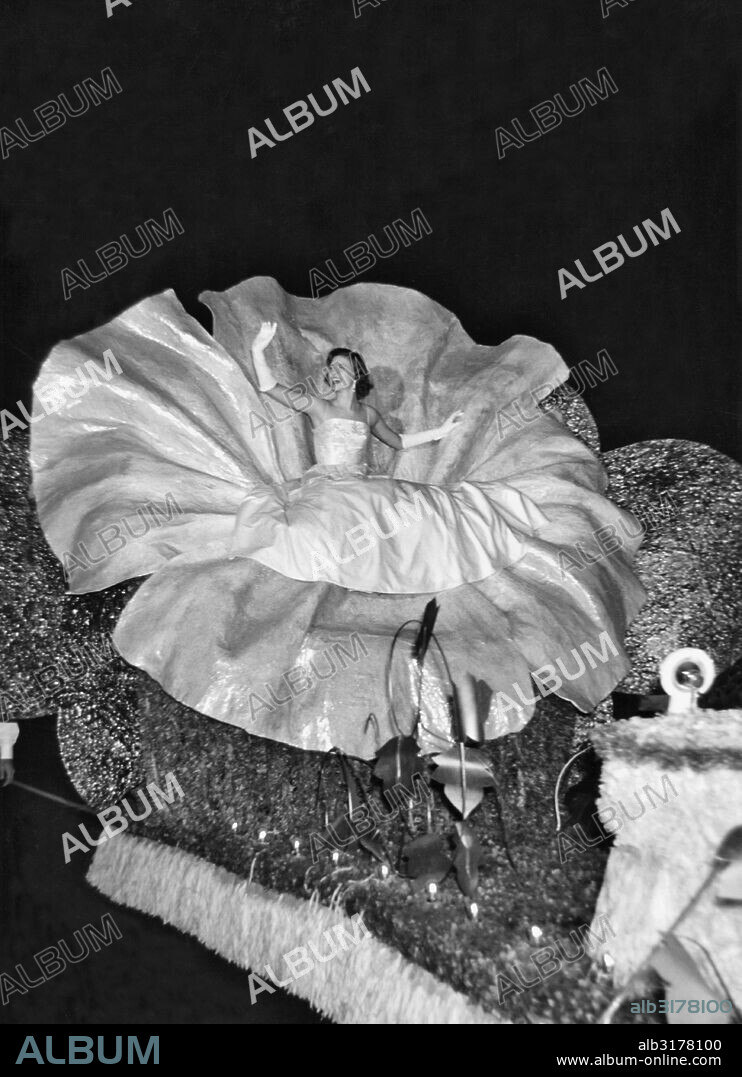 Memphis, Tennessee:  1955 The 1955 Maid of Cotton, DeLois Faulkner, seated within a huge cotton flower, rides her float during the 'King Cotton's Vacation' Parade of the Memphis Cotton Carnival.   © Underwood Archives / The Image Works.