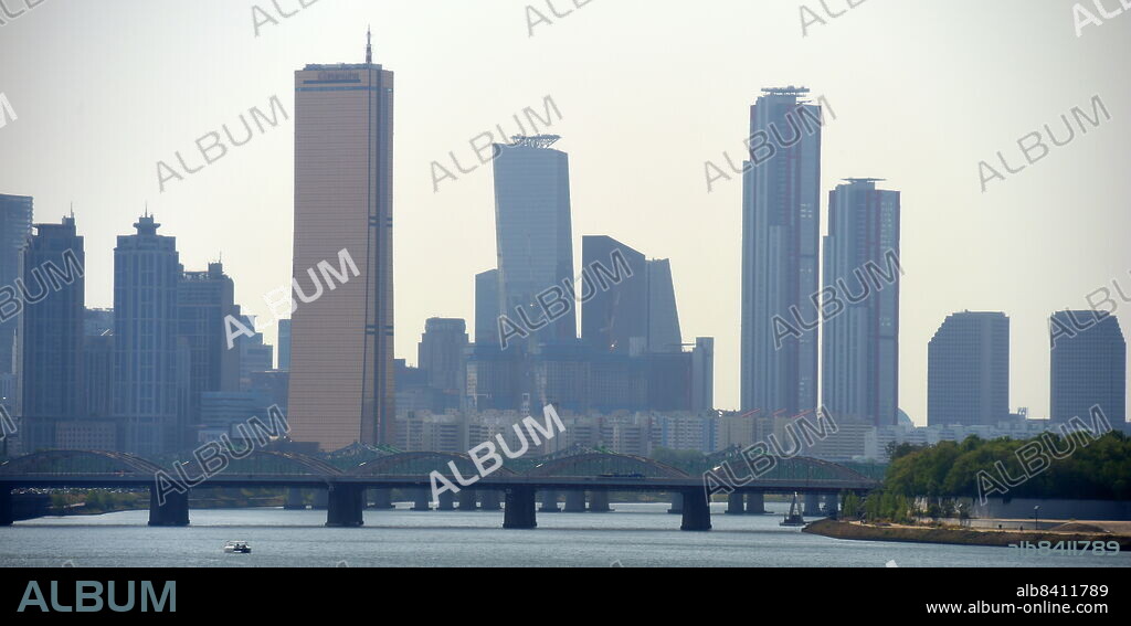 The Parc 1 Tower (right with red piping), is a supertall skyscraper in Seoul, South Korea. It stands 333 m (1,093 ft) and contain 69 floors. Construction stopped in 2011 but resumed in early 2017. Yeouido Han River Park, in Seoul, South Korea.