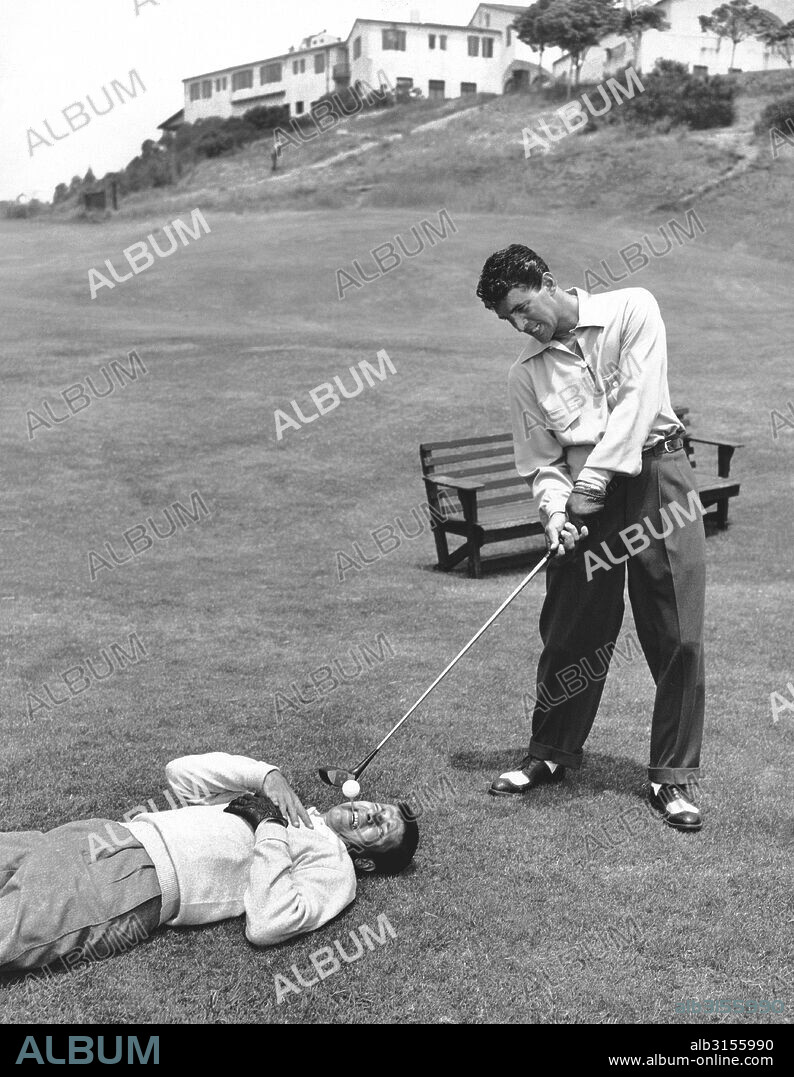 California:  c. 1953 Dean Martin appears to be ready to drive off a tee that Jerry Lewis is fearfully holding in his mouth.