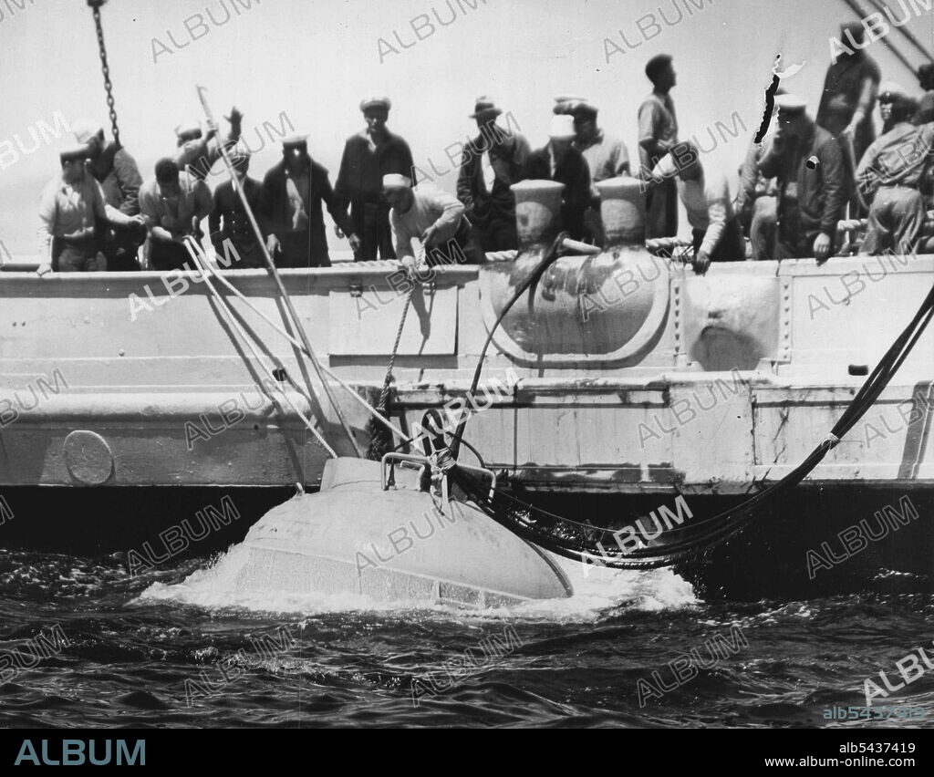 Diving Bell Lowered To Sunken Submarine -- Members of the salvage vessel Falcon are shown lowering a huge diving bell over the side of the rescue ship today to the sunken submarine Squalus, which went down yesterday near the isles of Shoals off the new Hampshire coast with 59 officers and crew. The diving bell was to be attached to the hatch of the stricken undersea ship by divers to permit a limited number of the entombed men to escape. The operation was to be repeated that seven men were broug.