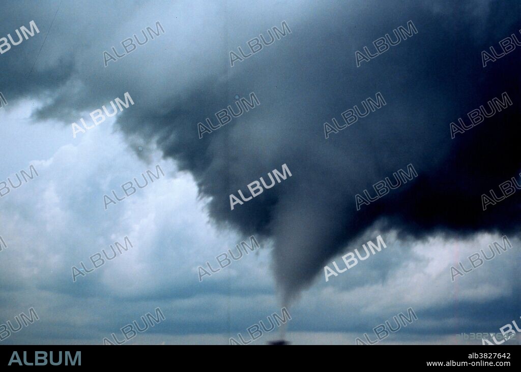 A tornado is a violent, dangerous, rotating column of air that is in contact with both the surface of the earth and a cumulonimbus cloud or, in rare cases, the base of a cumulus cloud. They are often referred to as a twister or a cyclone, although the word cyclone is used in meteorology in a wider sense, to name any closed low pressure circulation. Tornadoes come in many shapes and sizes, but are typically in the form of a visible condensation funnel, whose narrow end touches the earth and is often encircled by a cloud of debris and dust. Most tornadoes have wind speeds less than 110 miles per hour (177 km/h), are approximately 250 feet (80 m) across, and travel a few miles (several kilometers) before dissipating. The most extreme tornadoes can attain wind speeds of more than 300 mph (480 km/h), stretch more than two miles (3 km) across, and stay on the ground for dozens of miles (more than 100 km). Project Vortex-99. An occluded mesocyclone tornado rated an F3 by an NWS damage survey. Occluded means old circulation on a storm; this tornado was forming while the new circulation was beginning to form the tornadoes which preceeded the F5 Oklahoma City tornado. Photo #1 of sequence. Oklahoma, 10 mi. south of Anadarko May 3, 1999.