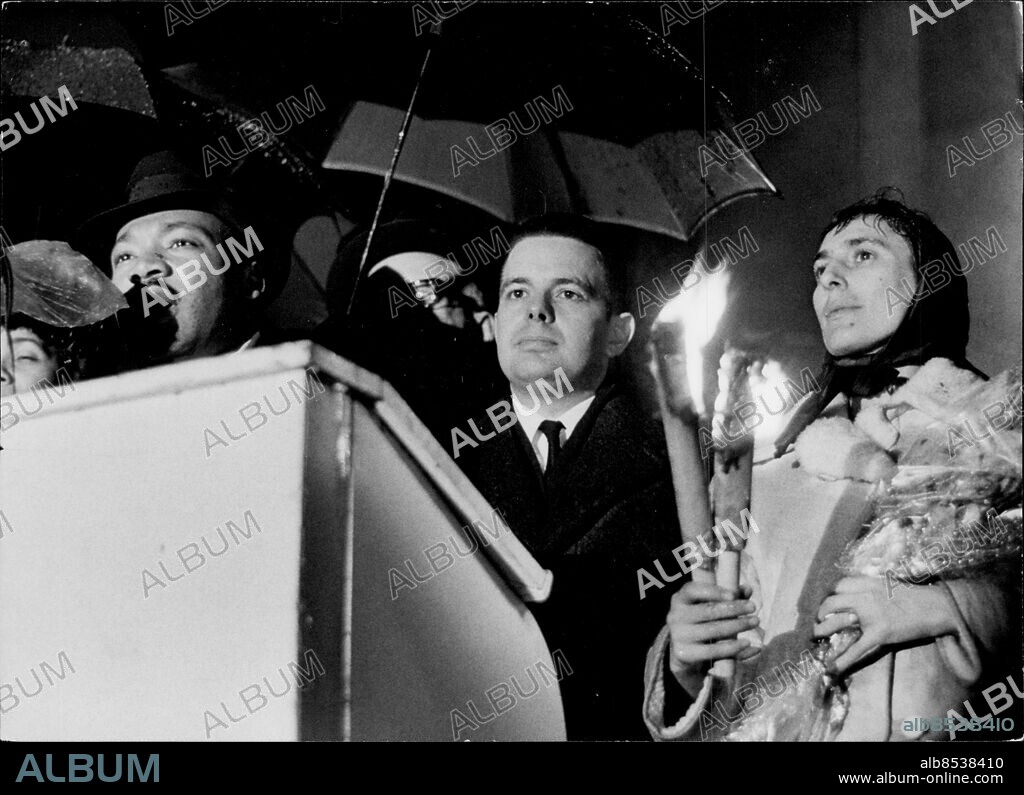 STOCKHOLM 1964-12-13. Amerikanske medborgarrättskämpen och fredspristagaren Martin Luther King Jr talar vid Olaus Petri-statyn utanför Storkyrkan i Stockholm 13:e december 1964, omgiven av Paul Rimmerfors och Katarina Taikon, efter ett fackeltåg mellan Kungsträdgården och Storkyrkan anordnat av Ungdomens fredsförbund.. Foto: Gunnar Lantz / SvD / TT / Kod: 11014.