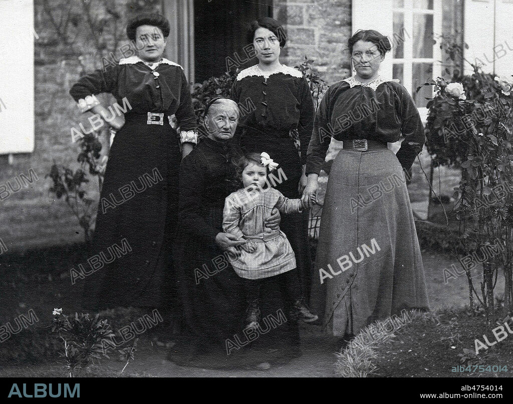 Femmes grand-mere et petite fille dans un jardin, elles ont toutes des corsages de velours cotelé, 3 soeurs et leur mere, l'une d'elle a eu une petite fille. Photo anonyme, photo de famille, vers 1900, 1910, debut 20eme siecle. Credit Collection KHARBINE TAPABOR.