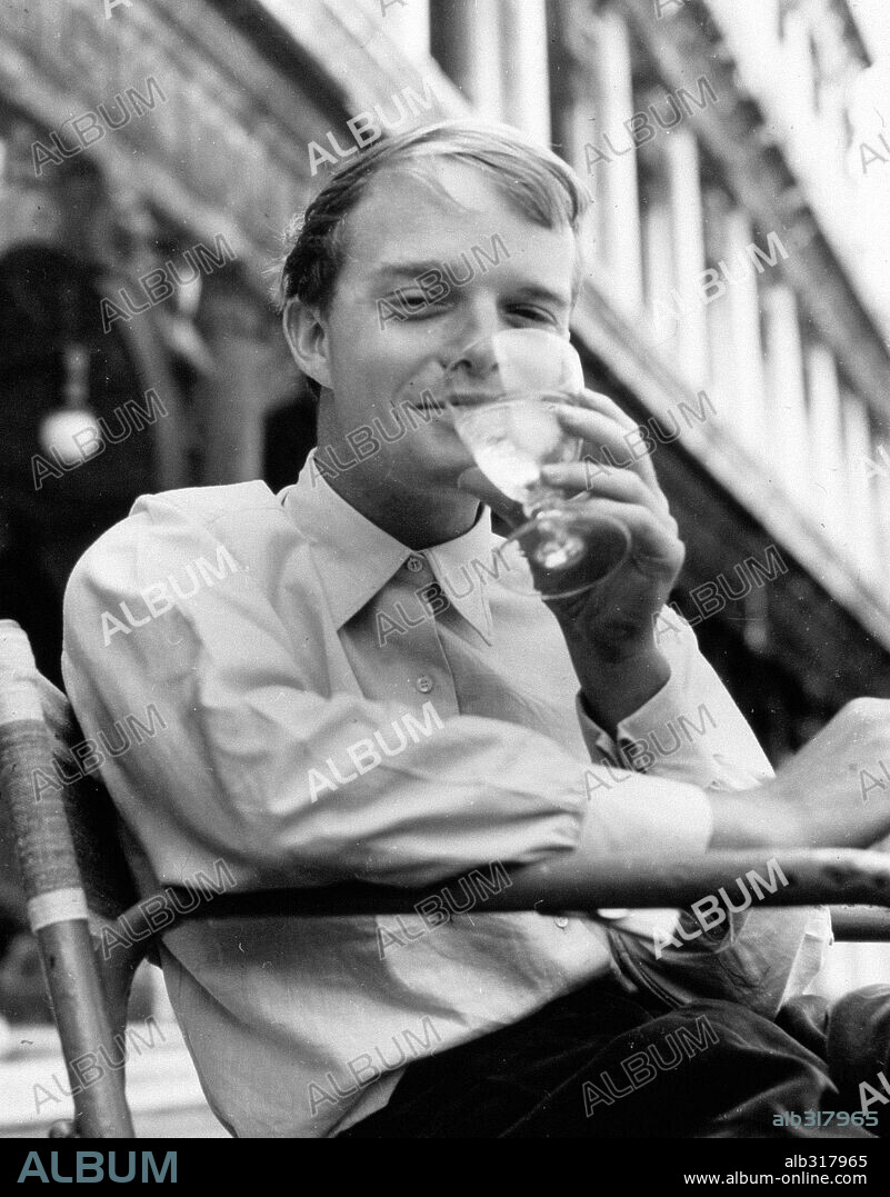 Young Truman Capote enjoying a glass of ice water at a cafe in Venice, Italy, where he is writing his first novel "The Grass Harp". 1950s.