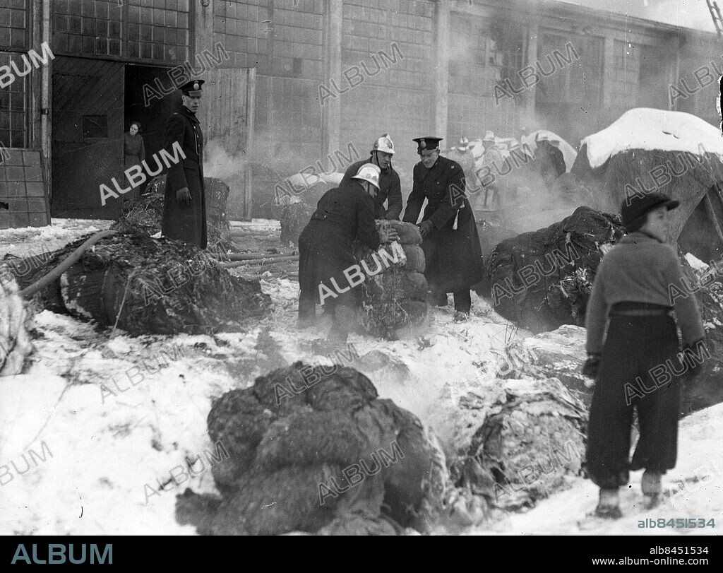 GÖTEBORG 1937-01-18.. Poliser hjälper brandmän vid brand. Det är fabriken Treco som brinner - madrass och trasselfabriken i Majorna. *** Local Caption *** GT Låda 1937-jan-01 Foto: Kamerareportage / TT / Kod: 2524.