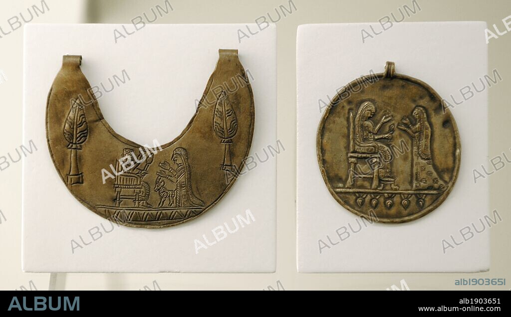Urartu civilization. Pectoral and gold medallion decorated with reliefs. The pectoral depicts the image of god Haldi on the throne and his wife Arubani. The madaillon, a seated goddess. From Tushpa or Toprakkale. 7th century B.C. Turkey. Pergamon Museum. Berlin. Germany.