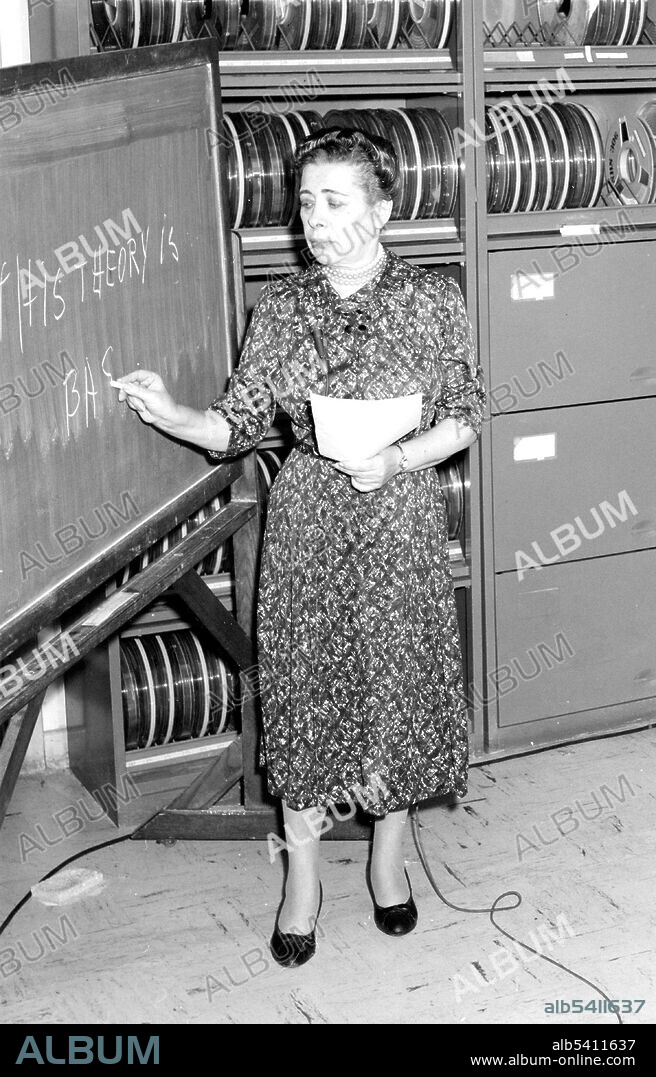 Filming of Ida Rhodes (left) at IBM. Rhodes demonstrates her pioneering work in computer translation of languages. Ida Rhodes (May 15, 1900 - February 1, 1986) was an American mathematician. She received her BA in mathematics in February, 1923 and her MA in September of the same year, graduating Phi Beta Kappa from Cornell University. She held numerous positions involving mathematical computations before she joined the Mathematical Tables Project in 1940, where she worked under Gertrude Blanch, whom she would later credit as her mentor. Rhodes was a pioneer in the analysis of systems of programming, and with Betty Holberton designed the C-10 programming language in the early 1950s for the UNIVAC I. She also designed the original computer used for the Social Security Administration. In 1949, the Department of Commerce awarded her a Gold Medal for significant pioneering leadership and outstanding contributions to the scientific progress of the Nation in the functional design and the application of electronic digital computing equipment. Though she retired in 1964, Rhodes continued to consult for the Applied Mathematics Division of the National Bureau of Standards until 1971. Her work became much more widely known after her retirement, as she took the occasion to travel around the globe, lecturing and maintaining international correspondence. She died in 1986 at the age of 85. No NIST photographer credited, November 16, 1960.