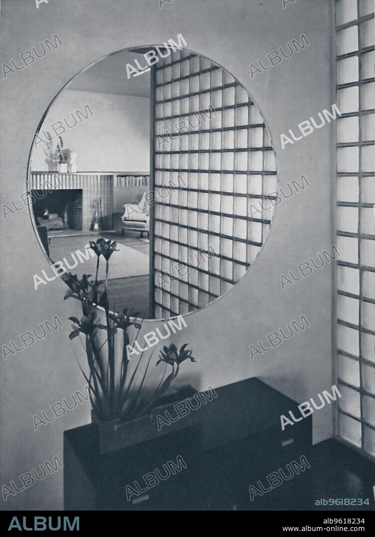 MICHAEL GOODMAN. 'Entrance hall in the house of Dr. and Mrs. James B. Graeser in Oakland, California, showning the glass brick screen which separates the hall from the dining-alcove, and a reflection of the living-room fireplace, made of Chinese blue tiles', 1939. From Decorative Art 1939 - The Studio Year Book, edited by C. G. Holme. [The Studio Ltd., London, 1939].