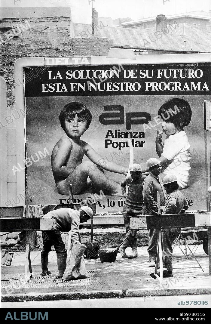 16/06/1977. Elecciones Generales de 1977. Obreros trabajando en la calle a lado de un cartel electoral de Alianza Popular.