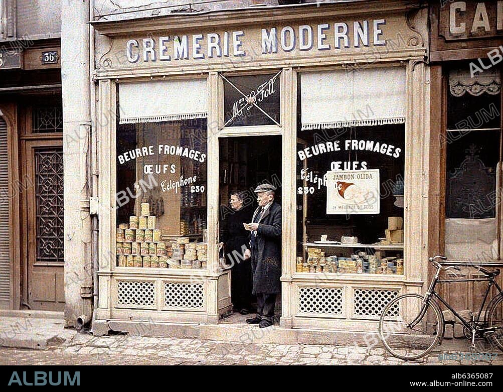 Reims (Marne, France), Le Foll, Crémerie Moderne (dairy).-Exterior view of a dairy with a man and a woman standing in the doorway.-Autochrome Lumière photo by Fernand Cuville (1887-1927), 1917 (World War I, Western front).