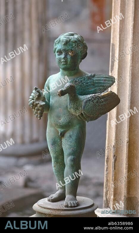 Pompeji, Haus der Vettier (Casa dei Vettii, VI,15,1), Peristyl, Bronzefigur eines Eroten, in der einen Hand Weintrauben, in der anderen Hand eine Ente, die als Wasserspeier fungierte, haltend. am Golf von Neapel (Italien, Kampanien). Pompeii, house of the Vettii (Casa dei Vettii, VI,15,1), in the peristyle, bronze figure of an erote Pompeji, Kampanien, Italien.