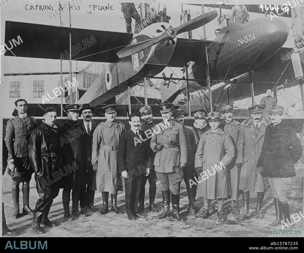 Caproni & his plane, Photograph shows Giovanni Battista Caproni (1886-1957), an Italian aeronautical engineer and founder of the Caproni aircraft manufacturing company with group of people in front of 'The Caproni Flight', an enormous triplane bomber N531., 1918 July 29, Glass negatives, 1 negative: glass.