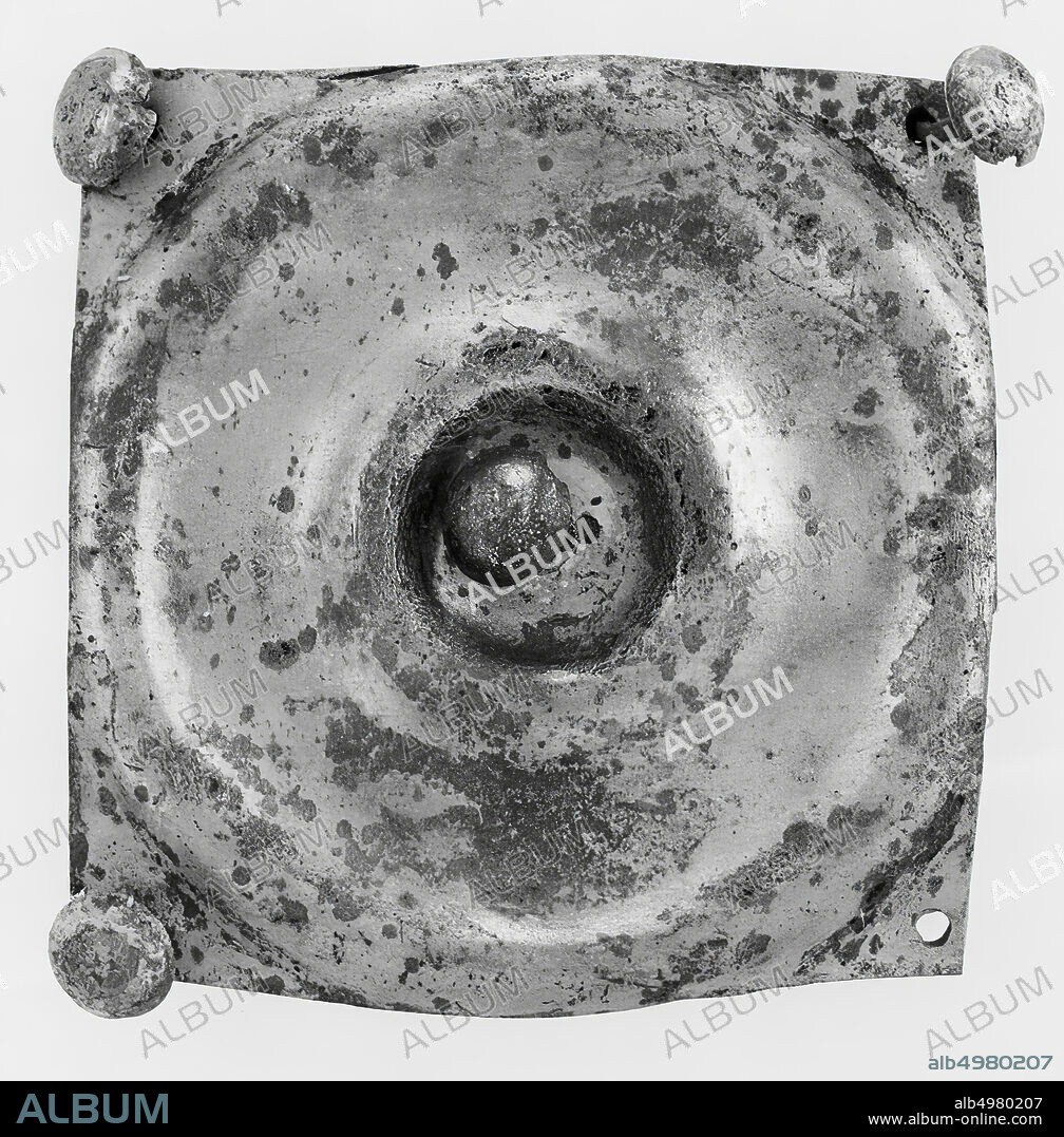 Plate of silvered bronze with a circular extruded decoration, consisting of a concave midfield with a pinhole in the center, then a convex edge followed by a concave ring, closed by a convex edge. This last edge is not exactly circular, the picture seems to be cut tight on two sides. There are pin holes on the 4 corners. In 3 of these are still the pins (as in the pin hole in the middle). The buttons of the pins consist of convex discs (diameter approx. 1 cm.). All pins are held in place by the corresponding rings., Phalera (appendix), metal, bronze (silvered), 6.95 x 6.7 cm, roman 1-100, the Netherlands, Gelderland, Renkum, Doorwerth, Rijn.
