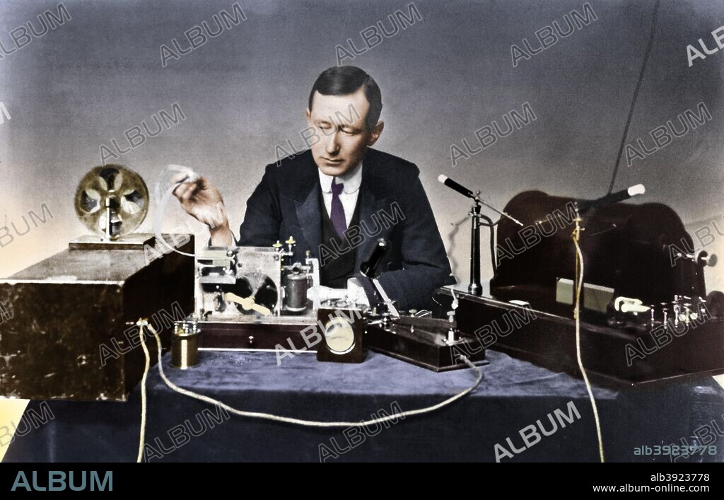 Guglielmo Marconi, Italian physicist and radio pioneer. Marconi with typical apparatus, including 10-inch induction coil spark transmitter (right), morse inker and 'grasshopper' key in centre. Photograph.
