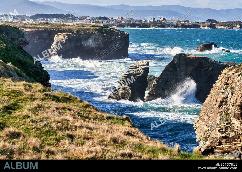 Playa de las Catedrales, monumento natural ubicado en la formación geomorfológica Rasa Cantábrica, en la provincia de Lugo. Se trata de una superficie plana situada entre el mar Cantábrico y las estribaciones montañosas, generando de esta manera un tipo de costas lineal en donde destaca la formación de playas a pié de acantilado y arenales separados a menudo por farallones. También es conocida como As Cátedras, Lugo, Galicia, Spain.