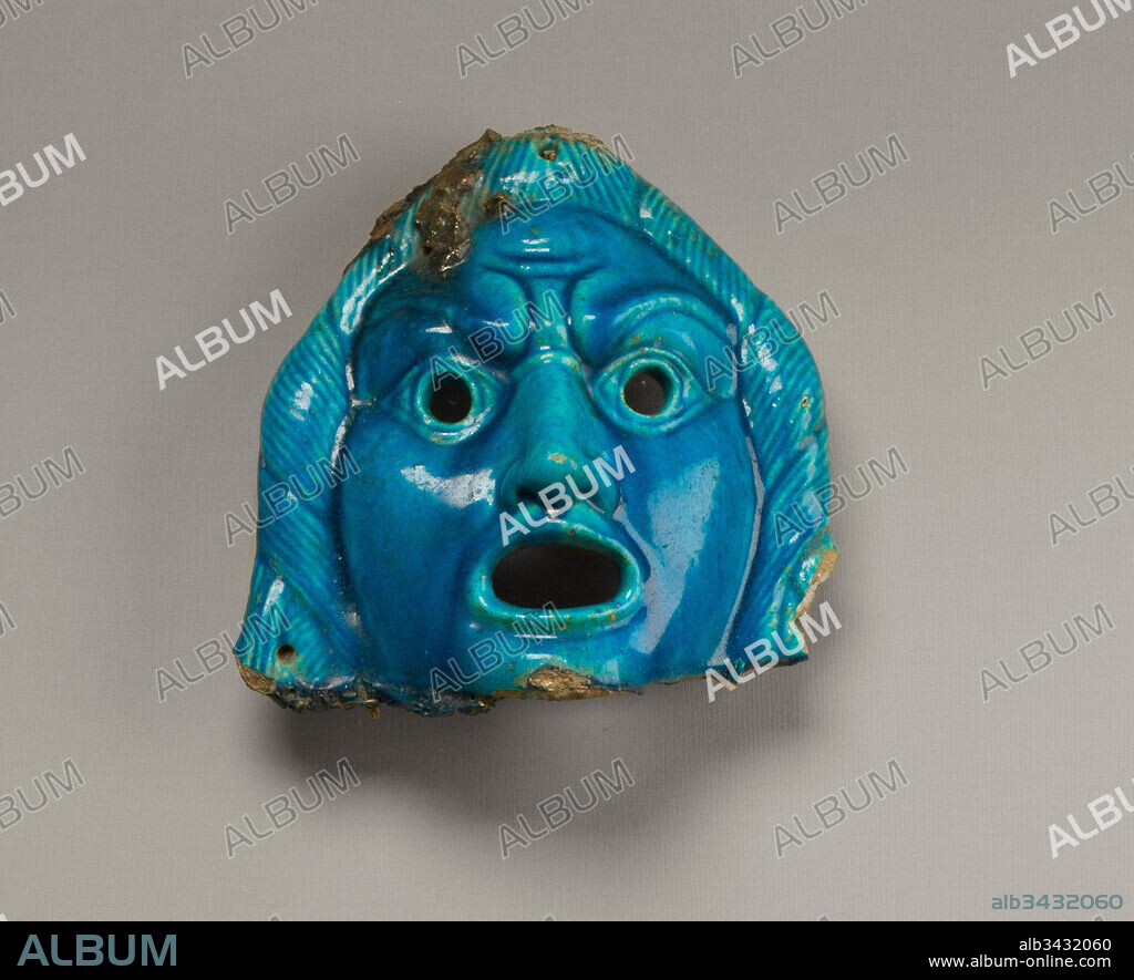 Theatrical mask for offering, Roman Period, A.D. 2nd century, From Egypt; Probably from Fayum, Medinet el-Fayum (Krokodilopolis-Arsinoe), faience, 19 x 19 cm (7 1/2 x 7 1/2 in.), This mask and the mask 26.71 are too small and brittle to have served as actual theater masks. They refer to the god Dionysus, patron of the theater and god of rebirth; in Egypt he was equated with Osiris.