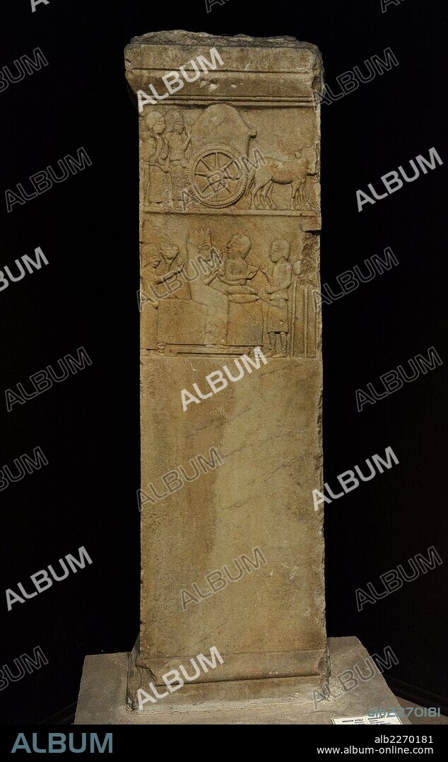 Anatolian-Persian funerary stele, 5th century BC. Marble. From Daskylaion (Ergili, Lake Manyas). Stele with depiction of a funerary cortege in two scenes: two mourning women walk behind a funeral cart (upper scene). A woman and a bearded man sit on a couch (lower scene). The woman's left hand holds an object, while her right hand receives an egg from the man. The couch is flanked by servants or slaves. On the right, the slave stands in front of a vessel placed on a tripod. On the left, the other slave carries a fruit bowl. Archaeological Museum. Istanbul, Turkey.