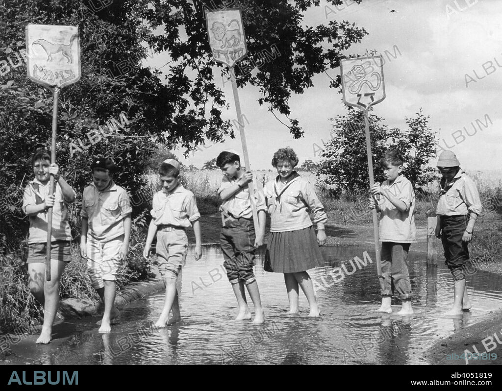 Bnei Akiva Children's Summer Camp, 1961. Children paddling and carrying placards written in Hebrew, at a camp organised by the Bnei Akiva (Bachad) charity which promotes Jewish religious education, and provides educational and vocational training for Jewish youth.