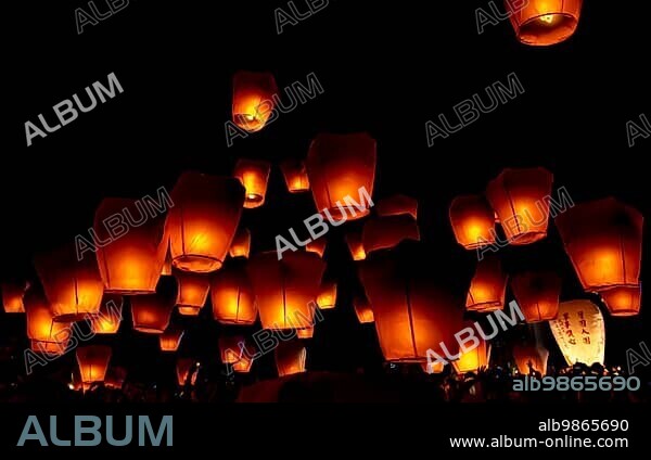 Glowing paper lanterns illuminate the night sky during the Pingxi sky lantern festival in Taiwan.