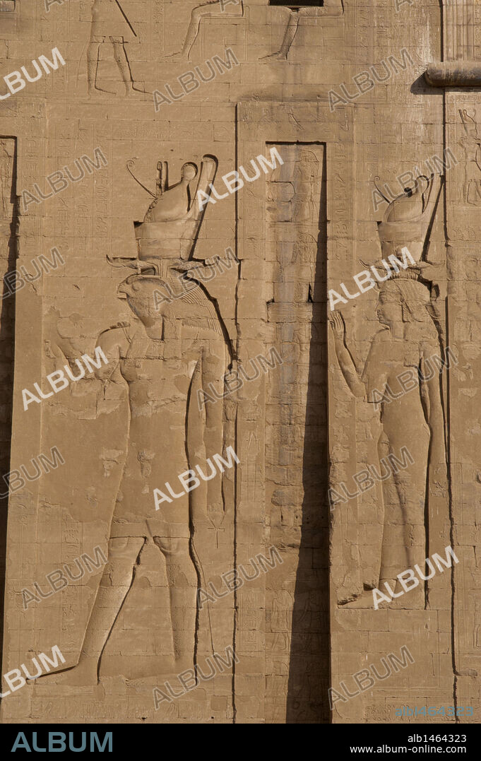 ARTE EGIPCIO. Dios HORUS (cabeza de halcón) y diosa HATHOR, ambos con la doble corona. Entrada principal. Primer pilón. Detalle. Templo de Horus. Edfú. Egipto.