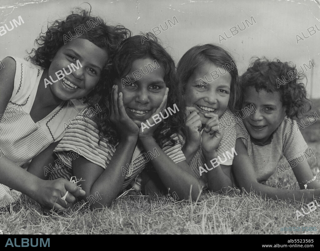 Little Girls from Far West at an Aborigines' Welfare Scheme holiday camp at La Perouse appreciate the finer points of a cricket match. Left to right: Fay Tayler, 10, Beryl Carney, 10, and Rita Fuller, 11. January 10, 1955.