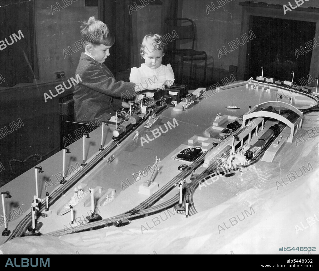 When Prince Charles arrives in Gibraltar he will be presented with this model of the Rock of Gibralter, complete with electric railway. It was made by boys of REME. Peter and Jacqueline Matthews are the lucky children sitting in the seats "reserved" for the Prince and Princess Anne. May 10, 1954. (Photo by Daily Mirror).