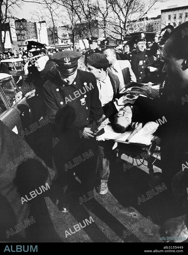 New York, New York:  February 21, 1965 Black activist Malcolm X is carried from the Audubon Ballroom where he had just been shot. He died shortly after.