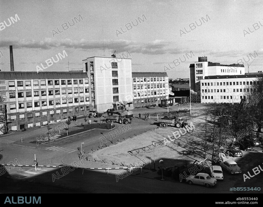 Lasarettet i Lund Lunds lasarett 1964.. Översiktsbilden visar tv baktill neurologblocket, AB, och th E-blocket, med bl a klinisk kemi och djurförsök. En gräv-skopa håller på att skrapa hål asfalten för den jättegrop där centralblocket skall byggas. I AB-blocket syns i mitten trapphuset med entréplanen som skall rivas för att lämna plats åt det stora nya blocket, man planerade så då bygg-naden för några år sedan uppfördes.. Foto: C.A.Raasum / Sydsvenskan / IBL Bildbyrå.
