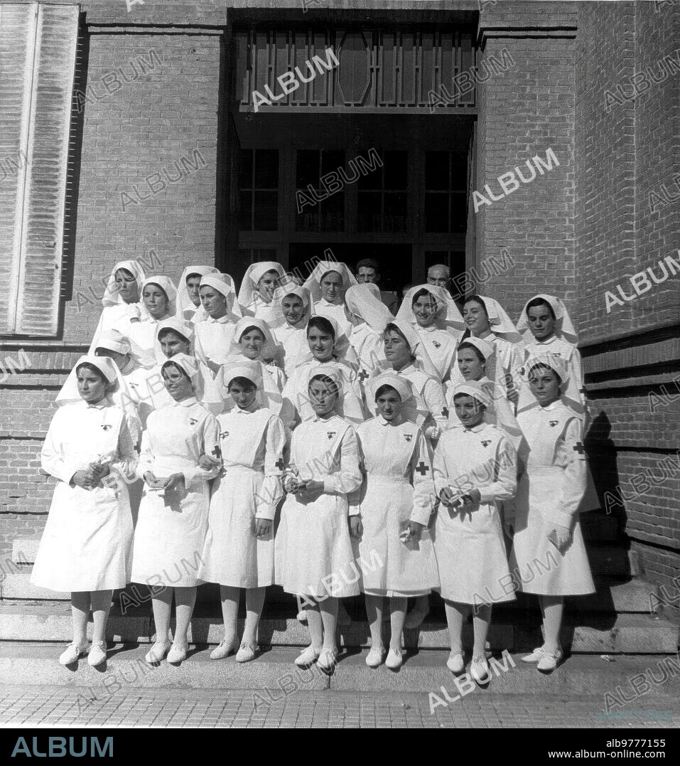 5 noviembre 1961. Grupo de Damas y Enfermeras de la cruz Roja A las Que, por haber Terminado el Curso, les Fueron Entregados los Brazaletes y Diplomas Correspondientes, en el acto celebrado en el dispensario Central, Presidido por el arzobispo de Sión y vicario general Castrense, doctor Alonso Muñoyerro, con el director general de beneficencia y presidente de la Institución, don Antonio María de Oriol.