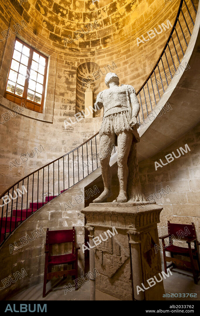19th-century elliptical spiral staircase and statue of the navigator Jaume Ferrer. Consolat de Mar (headquarters of the Balearic Government), 17th century. Palma, Mallorca, Balearic Islands, Spain.