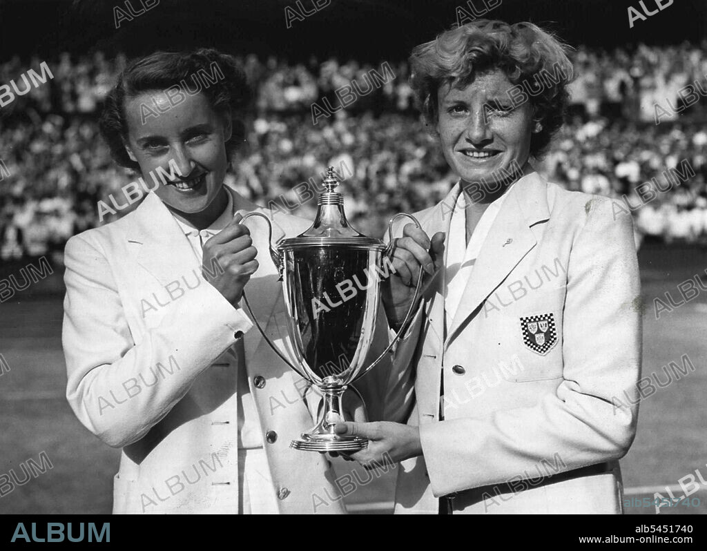 ***** Fortnight Finishes: Angela Mortimer (left) and Mrs. Shilcock, holding ***** Cup presented for the Women's Doubles.At one of the Wimbledon Lawn Tennis titles - the men's ***** - were fought out on Saturday the closing day of the *****. And in only one instance did the results against the form book. In the all British Women's Doubles expected winners Miss Pat Ward and Miss Shirley Bloomer ***** soundly beaten by their compatriots Angela Mortimer and ***** Shilcock. July 04, 1955. (Photo by Daily Express Pictures).