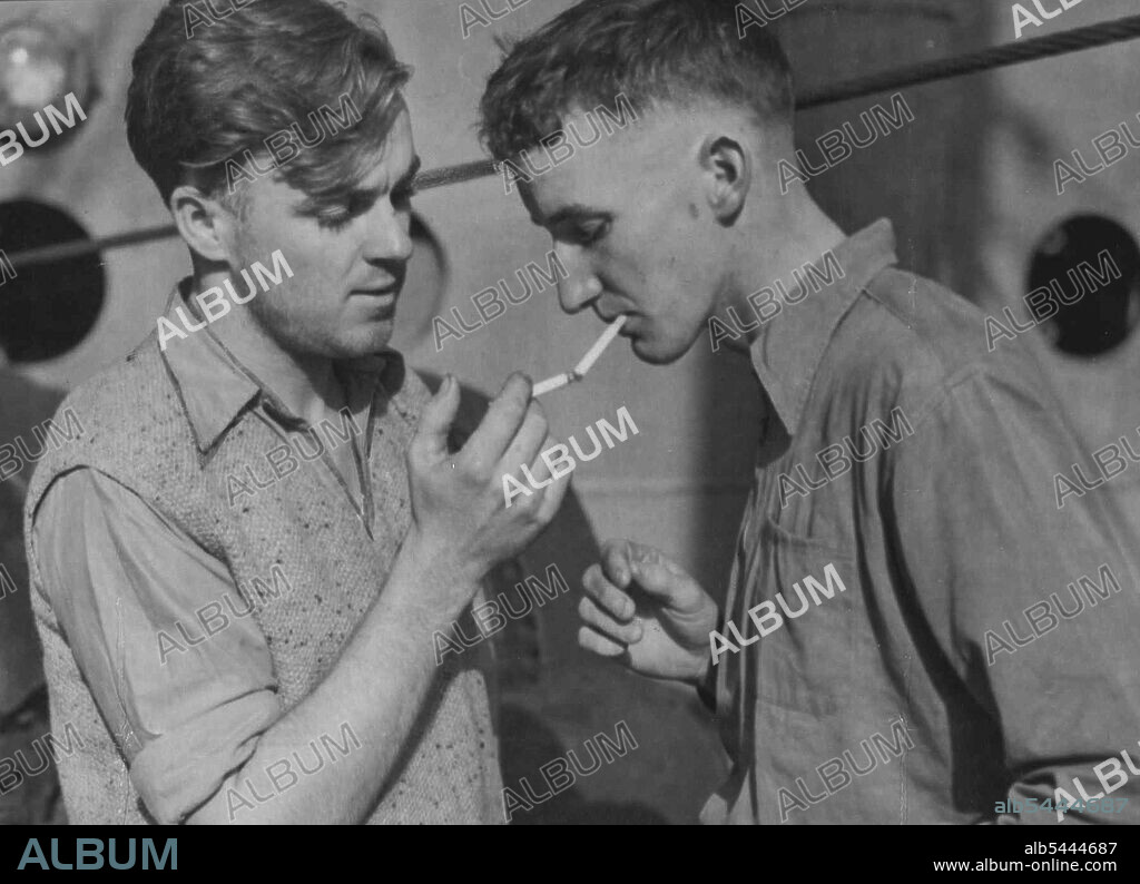 Fourth Engineer Bruce Miels and George Fisner, deck by on the torpedoed Australian ship, enjoys a smoke after being landed in port. Thirty-seven sailors lost their lives when the ship sank in 30 seconds. June 4, 1942.