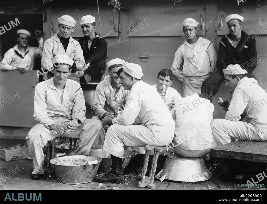 On Board the Battleship Arkansas, Sailors practice the time honored tradition of peeling potatoes in Kitchen Patrol Duties.