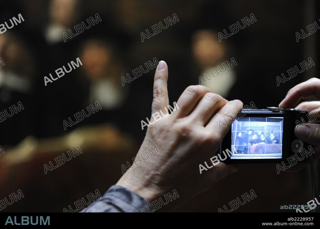 Persona fotografiando con cámara digietal un cuadro de REMBRANDT, tituldo LOS SINDICOS DEL GREMIO DE LOS PAÑEROS" (1662). Rijksmuseum. Amsterdam. Holanda.