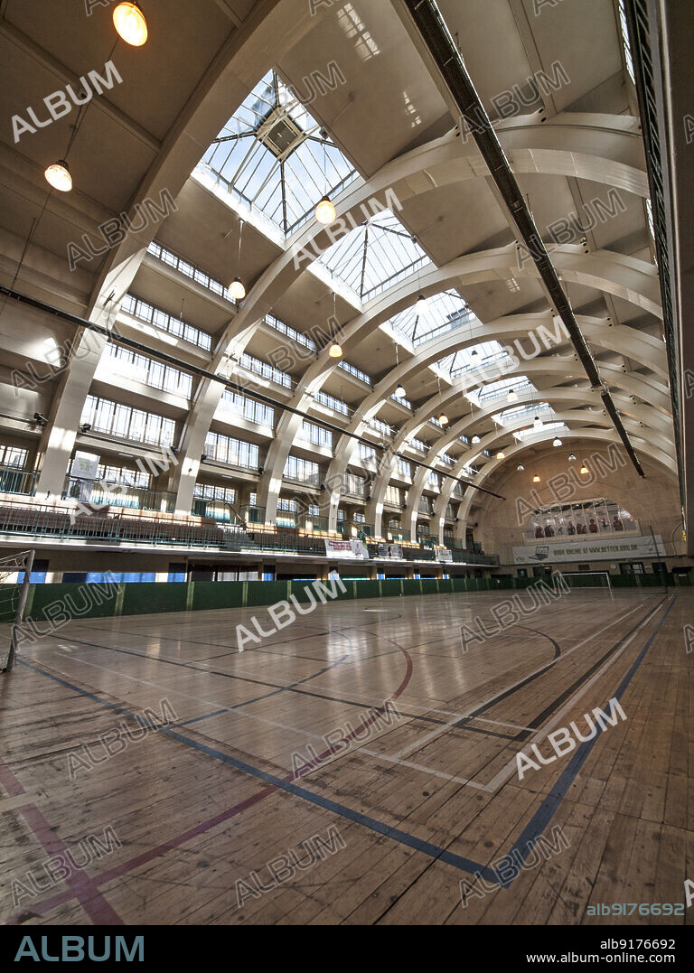 SIMON INGLIS. Seymour Leisure Centre, Seymour Place, City of Westminster, Greater London Authority, 2013. The former main swimming pool hall in Seymour Leisure Centre, formerly known as Seymour Place Baths, in use as a dry sports hall. The Seymour Place Baths (later known as Seymour Hall and Swimming Baths, and Seymour Leisure Centre) was officially opened in April 1937. The building was designed by Kenneth Mervyn Baskerville Cross for St Marylebone Borough Council. It is Grade II listed. The main swimming pool hall was designed to be converted into a public hall or cinema in the winter, and was surrounded by spectator galleries. The reinforced concrete roof structure was based on hangars in Orly, France (Freyssinet, 1921-23) and the Royal Horticultural Society exhibition hall in Victoria, London (1927-28). The main pool was converted into a dry sports hall in the mid 1980s, though the second class pool remained in use.